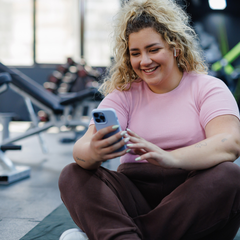 Woman looking at phone in gym