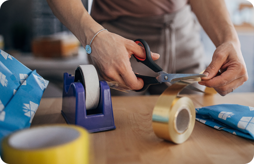 Close up of someone cutting tape for packing and gift wrapping