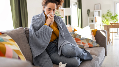 Person sitting on a couch using tissues