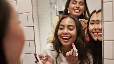 Three women leaning in toward each other for a group selfie.