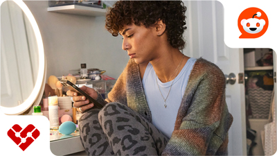 Person scrolling on a smartphone. Reddit logo. CMX heart.