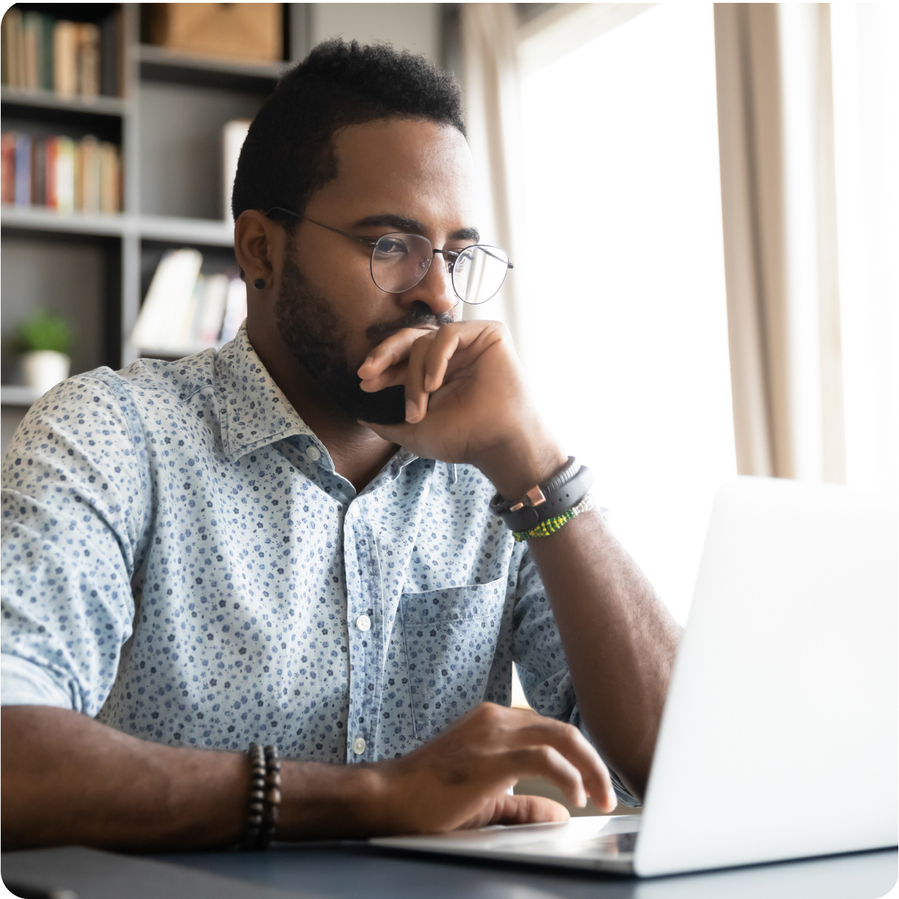 A man sitting at a desk in front of a laptop.