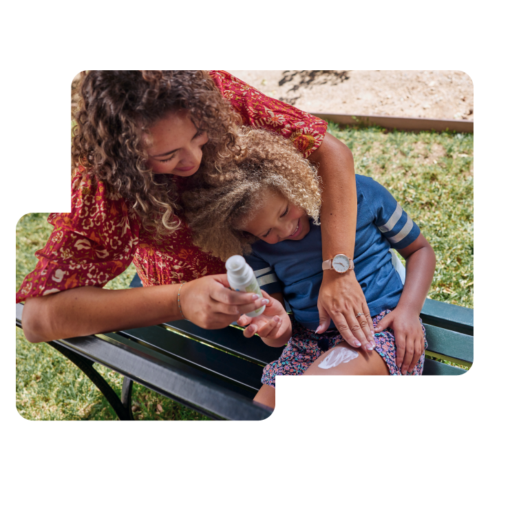 Mother applying sunscreen on child